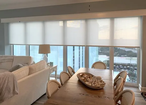 Coastal Alabama beach condo living and dining room with large windows serviced by Beach Blinds window treatments