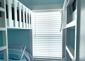 White faux wood horizontal blinds installed on kids bedroom window with bunk beds in Alabama home - Beach Blinds window coverings