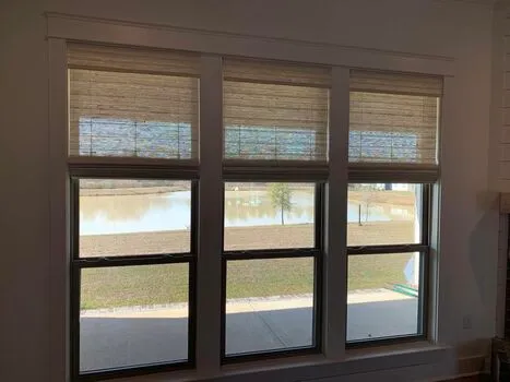 Natural woven wood bamboo shades installed on living room windows in Alabama home - Beach Blinds window coverings