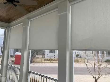 Outdoor light filtering solar roller shades installed on covered porch in Alabama home - Beach Blinds patio window coverings